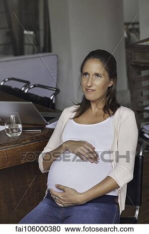 Pregnant woman cradling belly, portrait View Large Photo Image Stock Image - Pregnant woman cradling belly, portrait. Fotosearch