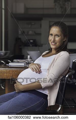 Pregnant woman cradling belly, portrait View Large Photo Image Stock Image - Pregnant woman cradling belly, portrait. Fotosearch
