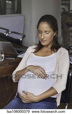 Pregnant woman cradling belly, portrait View Large Photo Image Stock Photo - Pregnant woman cradling belly, portrait. Fotosearch