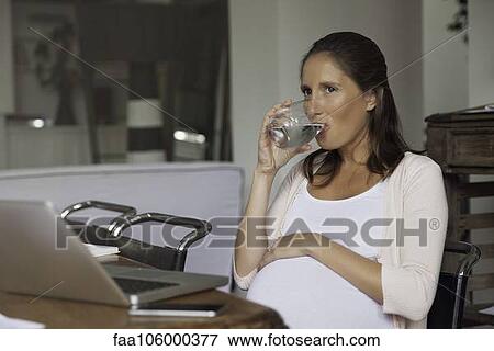 Pregnant woman hydrating View Large Photo Image Stock Photo - Pregnant woman hydrating. Fotosearch