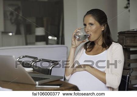 Stock Photo - Pregnant woman hydrating. Fotosearch