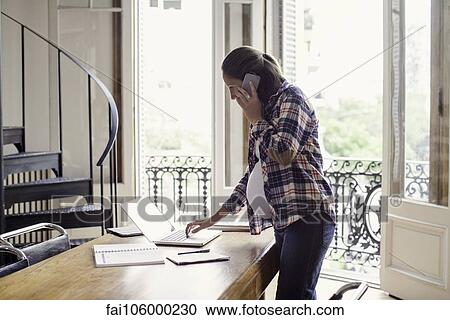 Stock Image - Pregnant woman working from home. Fotosearch