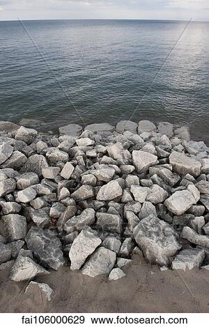 Rocks piled along shore View Large Photo Image Stock Photo - Rocks piled along shore. Fotosearch