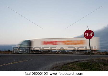 Semi truck moving on road near stop sign View Large Photo Image Stock Image - Semi truck moving on road near stop sign. Fotosearch