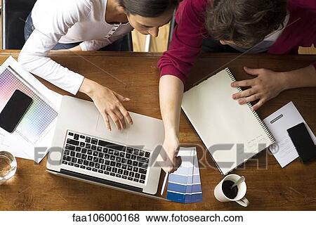 Stock Photo - Team members collaborating on project. Fotosearch