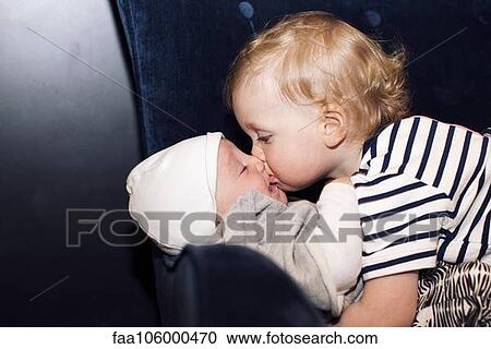 Stock Image - Toddler embracing infant sibling. Fotosearch