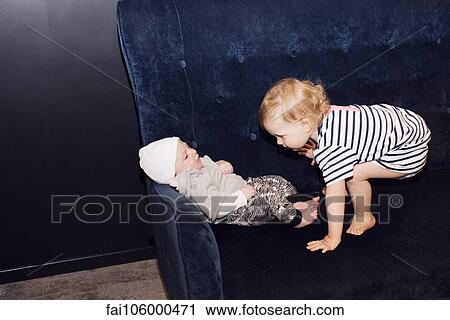 Toddler playing with infant sibling View Large Photo Image Stock Image - Toddler playing with infant sibling. Fotosearch