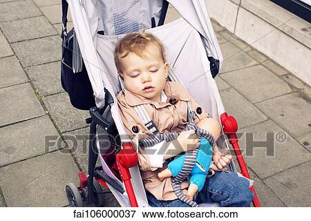 Stock Photo - Toddler sleeping in stroller. Fotosearch