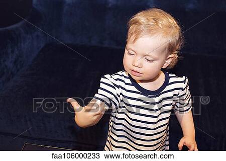 Stock Image - Toddler staring at hand in wonder. Fotosearch