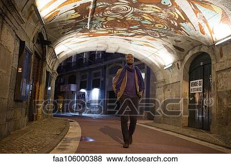 Traveler strolling through graffitied walkway View Large Photo Image Stock Photo - Traveler strolling through graffitied walkway. Fotosearch