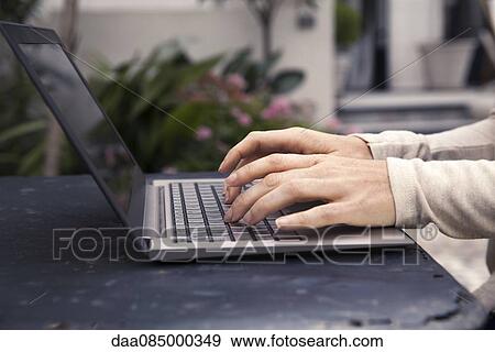 Using laptop outdoors View Large Photo Image Stock Photo - Using laptop outdoors. Fotosearch