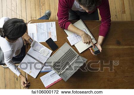 Using smartphone and laptop to manage home finances View Large Photo Image Stock Image - Using smartphone and laptop to manage home finances. Fotosearch