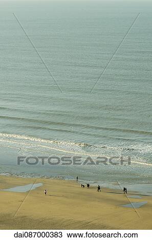 Vacationers walking on beach View Large Photo Image Stock Image - Vacationers walking on beach. Fotosearch