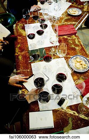 Stock Image - Wine testers taking notes during wine tasting. Fotosearch