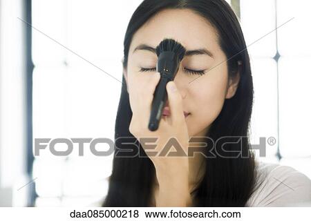 Woman applying face powder View Large Photo Image Stock Photo - Woman applying face powder. Fotosearch