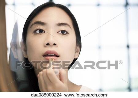 Woman applying lipstick View Large Photo Image Picture - Woman applying lipstick. Fotosearch