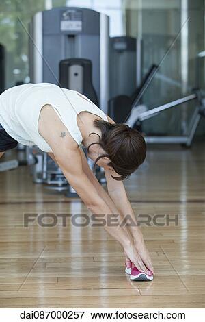 Woman bending over to touch toes View Large Photo Image Stock Photo - Woman bending over to touch toes. Fotosearch