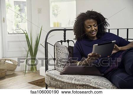 Stock Image - Woman connecting to social media using digital tablet. Fotosearch