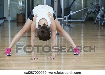 Woman doing a standing forward bend View Large Photo Image Stock Photo - Woman doing a standing forward bend. Fotosearch