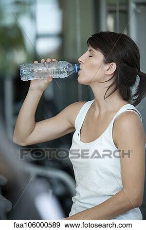 Woman drinking water after a workout View Large Photo Image Stock Photo - Woman drinking water after a workout. Fotosearch