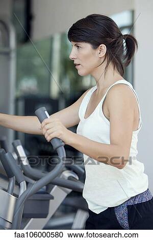 Woman exercising in fitness club View Large Photo Image Stock Image - Woman exercising in fitness club. Fotosearch