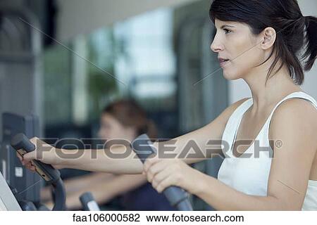 Woman exercising in fitness club View Large Photo Image Stock Image - Woman exercising in fitness club. Fotosearch