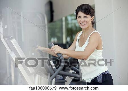 Woman exercising in fitness club, smiling cheerfully View Large Photo Image Stock Photo - Woman exercising in fitness club, smiling cheerfully. Fotosearch