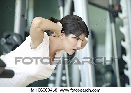 Stock Photo - Woman exercising in health club. Fotosearch