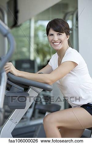 Woman exercising in health club, smiling cheerfully View Large Photo Image Stock Photograph - Woman exercising in health club, smiling cheerfully. Fotosearch