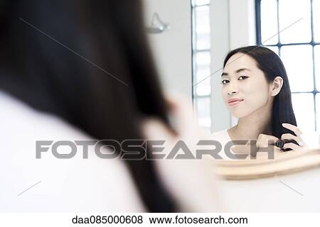 Stock Photo - Woman fixing her hair. Fotosearch
