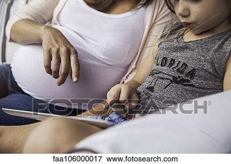 Woman helping daughter using educational app on digital tablet View Large Photo Image Stock Photo - Woman helping daughter using educational app on digital tablet. Fotosearch
