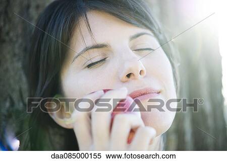 Woman holding apple against her face, eyes closed View Large Photo Image Stock Photography - Woman holding apple against her face, eyes closed. Fotosearch