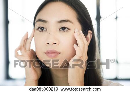 Woman holding finger tips on face View Large Photo Image Stock Photo - Woman holding finger tips on face. Fotosearch