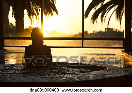 Woman in indoor pool during sunset View Large Photo Image Stock Photo - Woman in indoor pool during sunset. Fotosearch