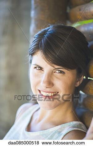Woman leaning against wall, smiling, portrait View Large Photo Image Stock Photo - Woman leaning against wall, smiling, portrait. Fotosearch