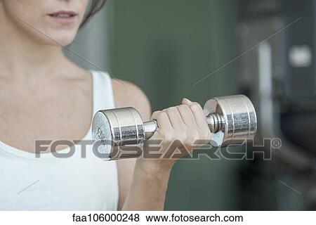 Woman lifting dumbbell, cropped View Large Photo Image Stock Photo - Woman lifting dumbbell, cropped. Fotosearch