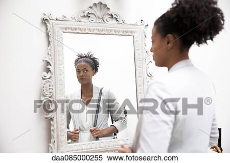 Woman looking at self in mirror View Large Photo Image Stock Photography - Woman looking at self in mirror. Fotosearch