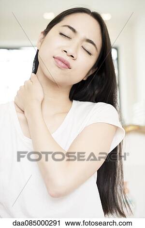 Woman massaging her neck View Large Photo Image Stock Image - Woman massaging her neck. Fotosearch