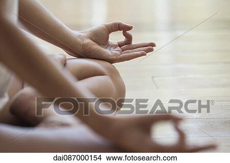 Woman meditating in lotus position, cropped View Large Photo Image Picture - Woman meditating in lotus position, cropped. Fotosearch
