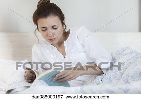 Woman reading in bed View Large Photo Image Stock Photo - Woman reading in bed. Fotosearch