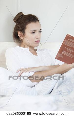 Woman reading in bed View Large Photo Image Stock Photo - Woman reading in bed. Fotosearch