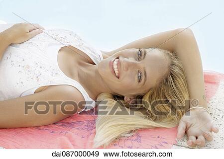 Stock Photo - Woman relaxing at poolside, portrait. Fotosearch