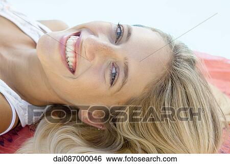 Stock Photograph - Woman relaxing at poolside, portrait. Fotosearch