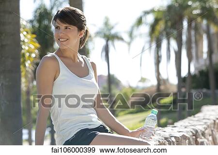 Woman relaxing in park with bottle of water View Large Photo Image Stock Photo - Woman relaxing in park with bottle of water. Fotosearch