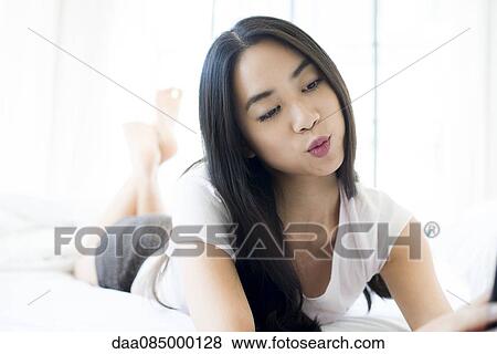 Stock Photo - Woman relaxing on bed. Fotosearch