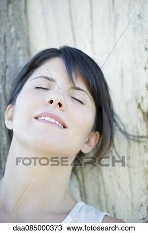 Woman resting head on tree trunk with eyes closed View Large Photo Image Stock Image - Woman resting head on tree trunk with eyes closed. Fotosearch
