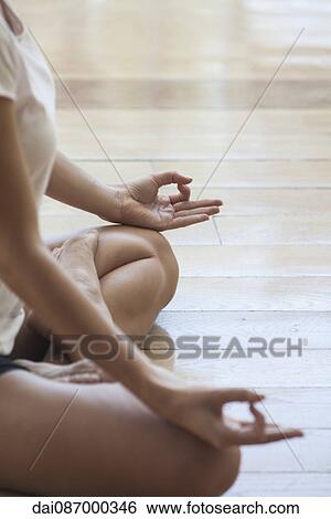 Woman seated in yoga lotus position, cropped View Large Photo Image Stock Photograph - Woman seated in yoga lotus position, cropped. Fotosearch
