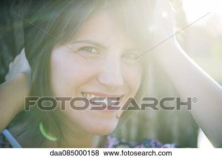 Woman smiling cheerfully outdoors, portrait View Large Photo Image Stock Photo - Woman smiling cheerfully outdoors, portrait. Fotosearch