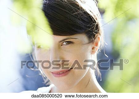 Woman smiling outdoors, portrait View Large Photo Image Stock Image - Woman smiling outdoors, portrait. Fotosearch