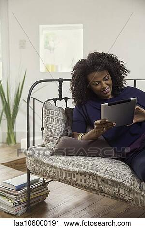 Woman streaming online video content on digital tablet View Large Photo Image Stock Image - Woman streaming online video content on digital tablet. Fotosearch
